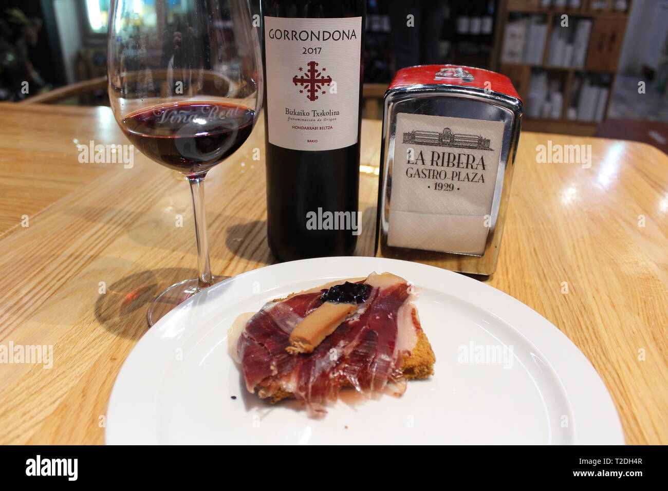 Jamón und Foie-Toast mit einem Glas Gorrondona-Rotwein Txakoli in der La Ribera Gastro Plaza, Bilbao, Spanien Stockfoto