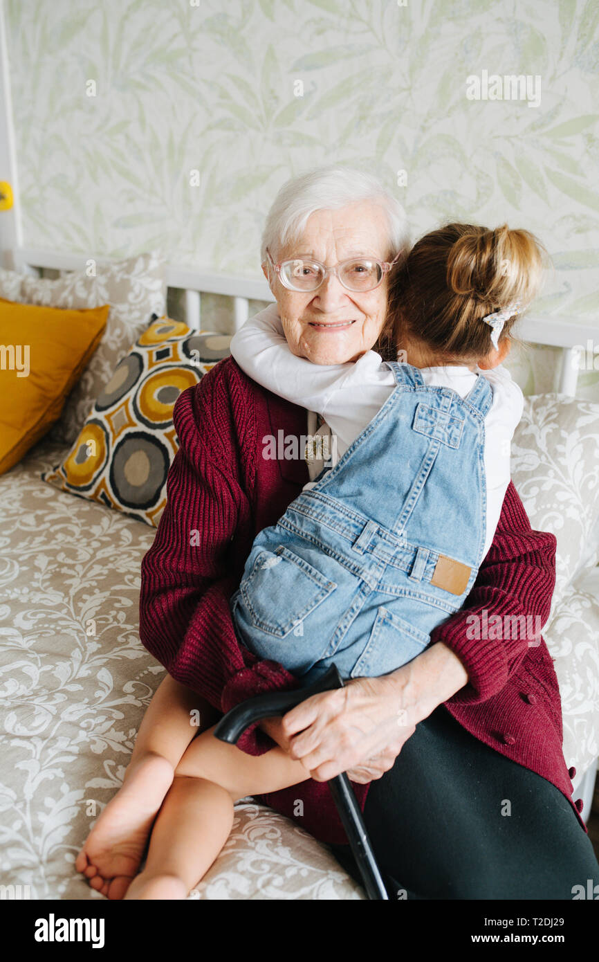 Glückliche Momente mit ihrer Urgroßmutter, ältere Dame viel Zeit mit ihrem großen Enkelin. Happy hug Stockfoto