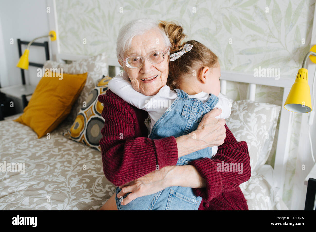 Glückliche Momente mit ihrer Urgroßmutter, ältere Dame viel Zeit mit ihrem großen Enkelin. Happy hug Stockfoto