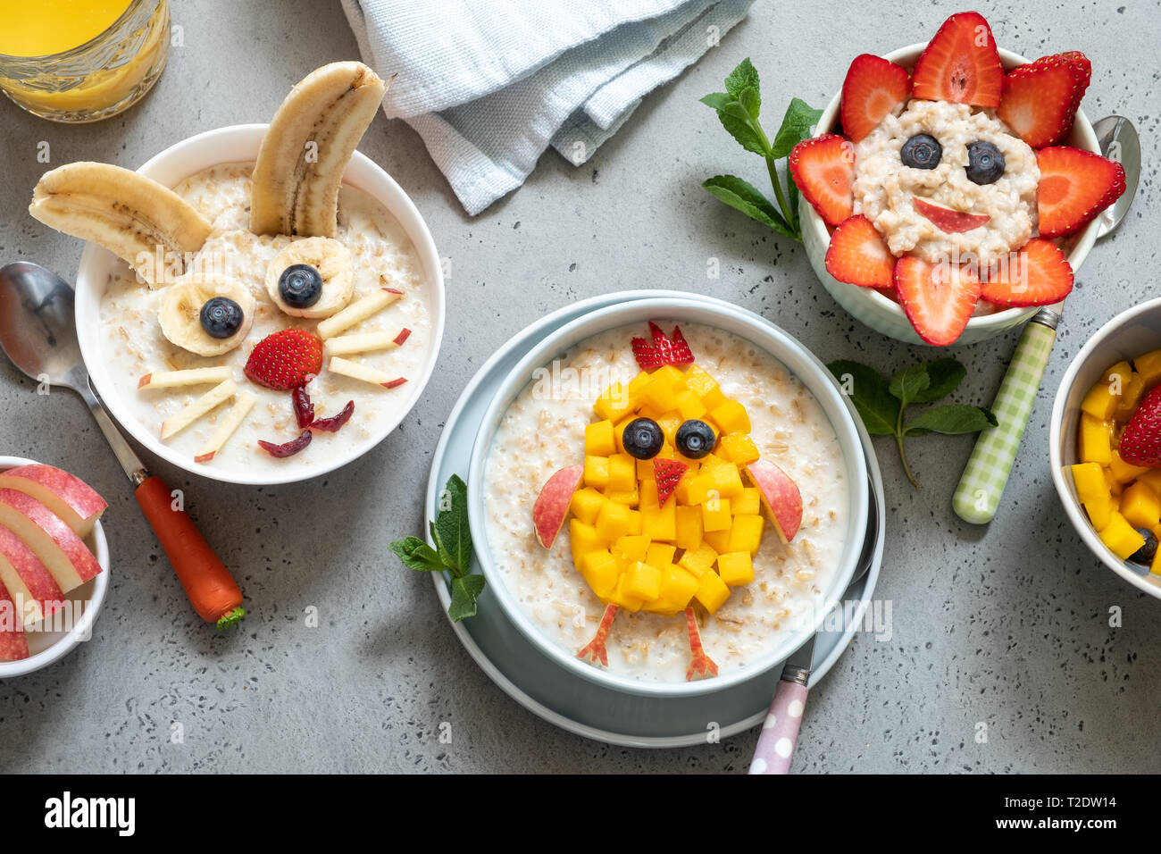 Lustige Schüsseln mit Haferflockenbrei mit Häschen, Küken und Blume für Ostern Stockfoto
