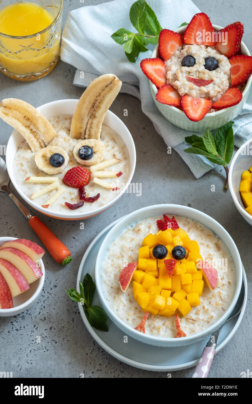 Lustige Schüsseln mit Haferflockenbrei mit Häschen, Küken und Blume für Ostern Stockfoto