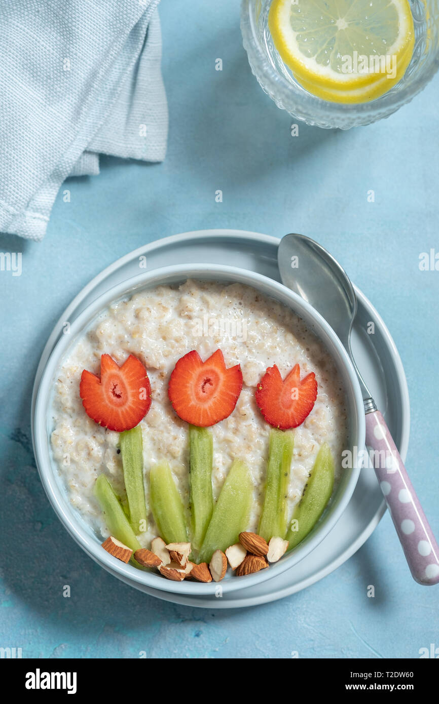 Lustige Schüsseln mit Haferflocken Porridge mit Frühling Blumen Stockfoto