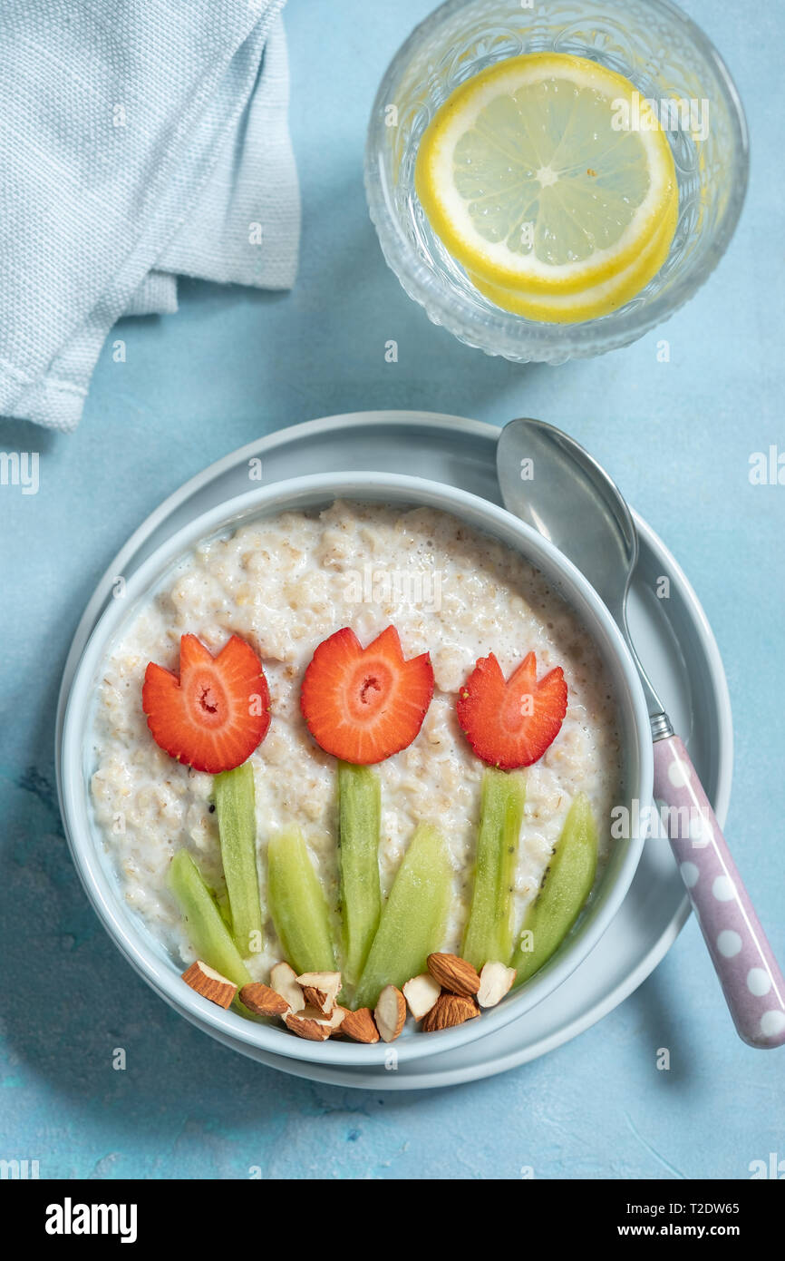 Lustige Schüsseln mit Haferflocken Porridge mit Frühling Blumen Stockfoto