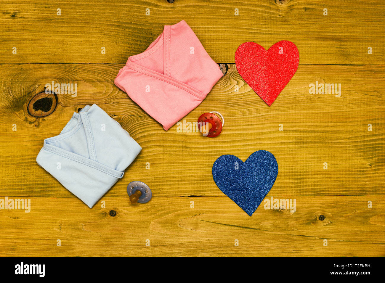 Baby Zubehör für Jungen und Mädchen und das Herz Form auf Holztisch. Baby Ankündigung Konzept. Getönten Foto. Stockfoto