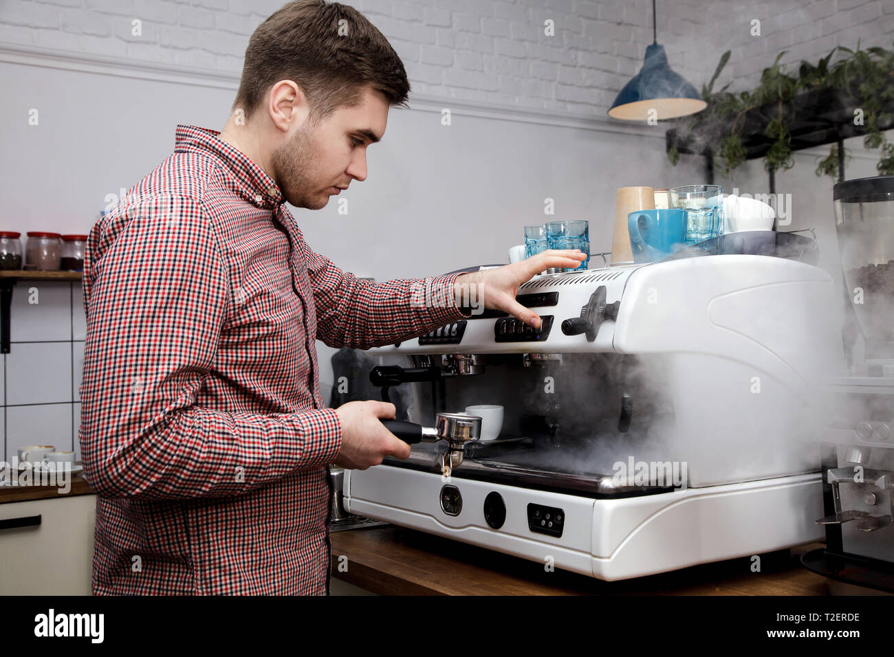 Junge schöne Barista hipster Kaffee für seine Kunden im Cafe. Stockfoto