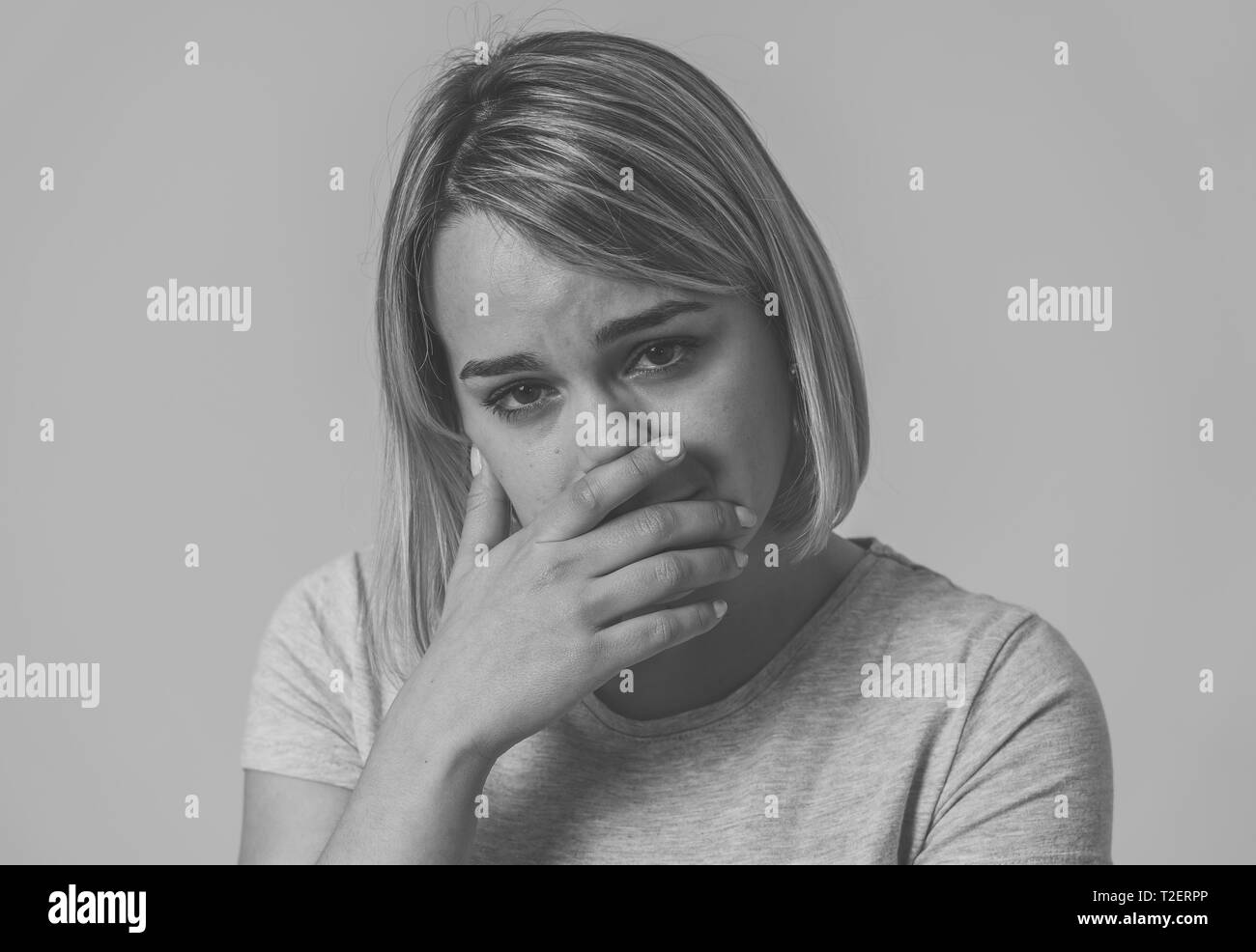 Schwarz-weiß-Porträt der jungen Frau traurig, ernst und besorgt, beunruhigt und empört. Über den Mund in den Schmerz. Mit weißen kopieren. Stockfoto
