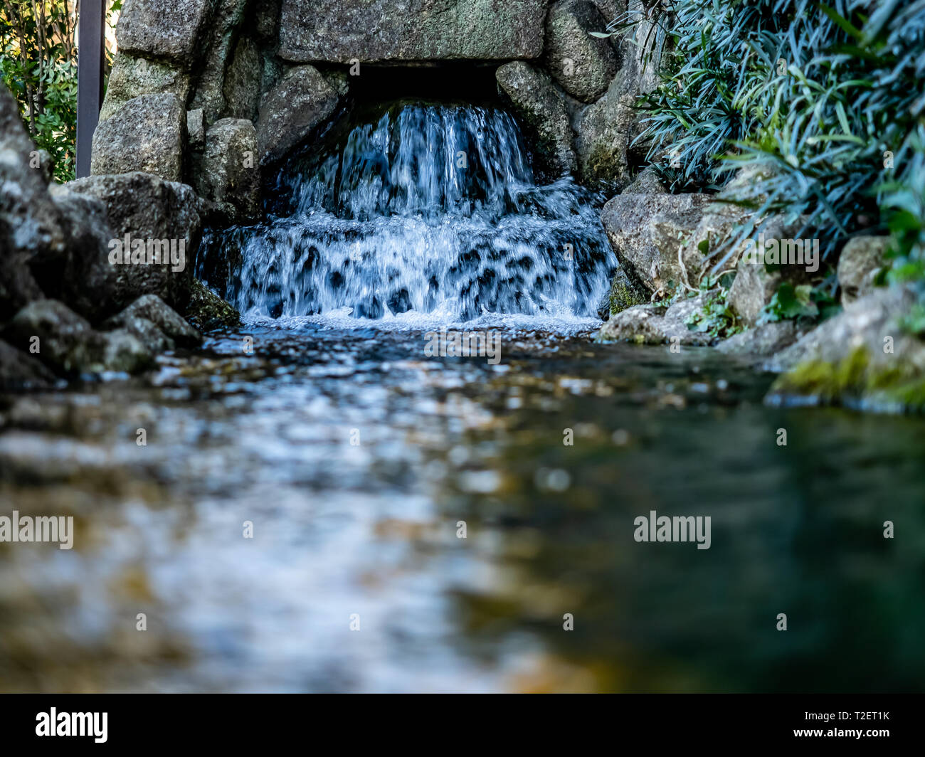 Wasserkaskaden von einem Wasser Pumpstation in einem fließenden Wasserspiel entlang eines Wanderweges in Yokohama, Japan. Stockfoto