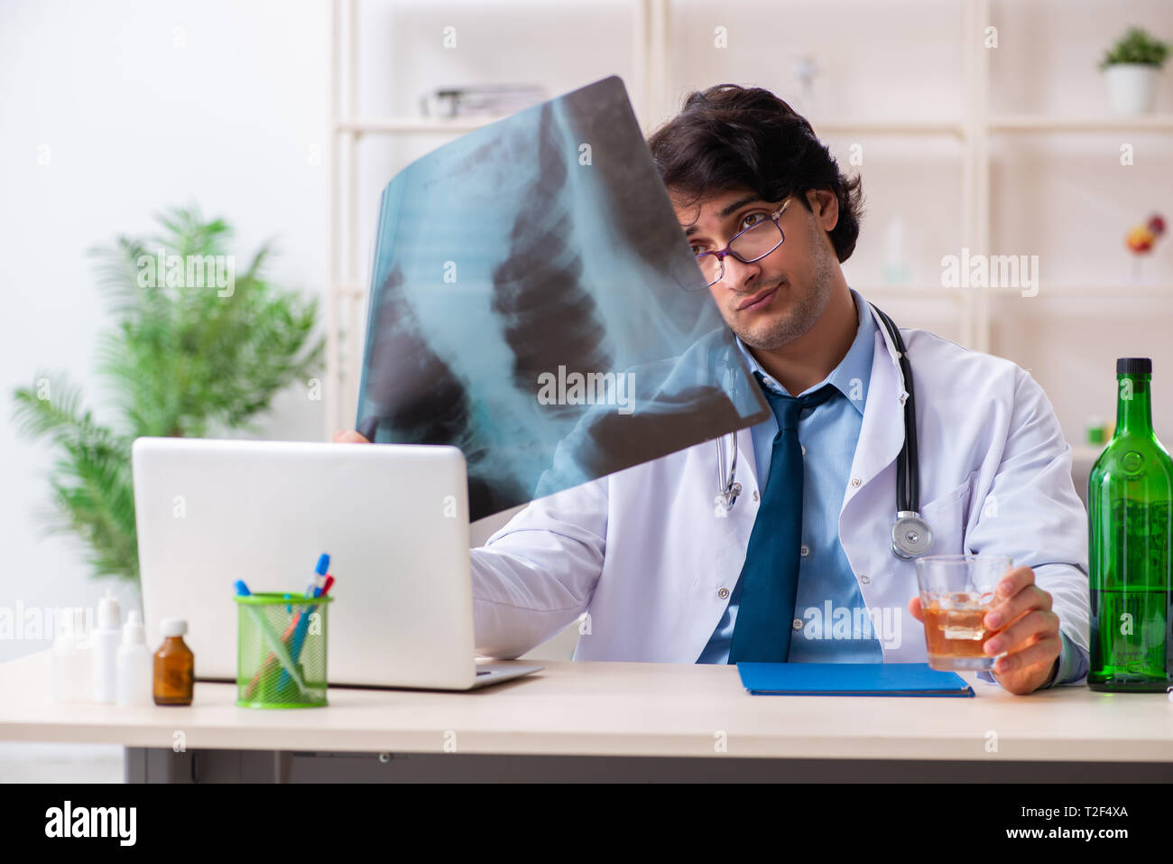 Junge männliche Arzt trinken im Büro Stockfoto