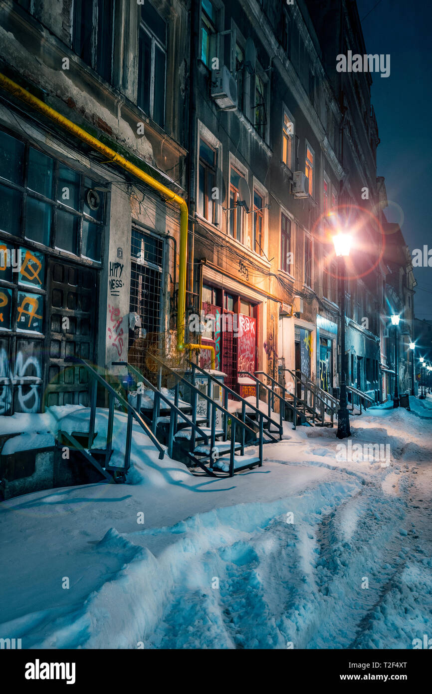 Schöne alte Gasse mit Schnee im winter Downtown in Bukarest mit alten Gebäuden in der Nacht gut von Laternen beleuchteten Schuß abgedeckt Stockfoto