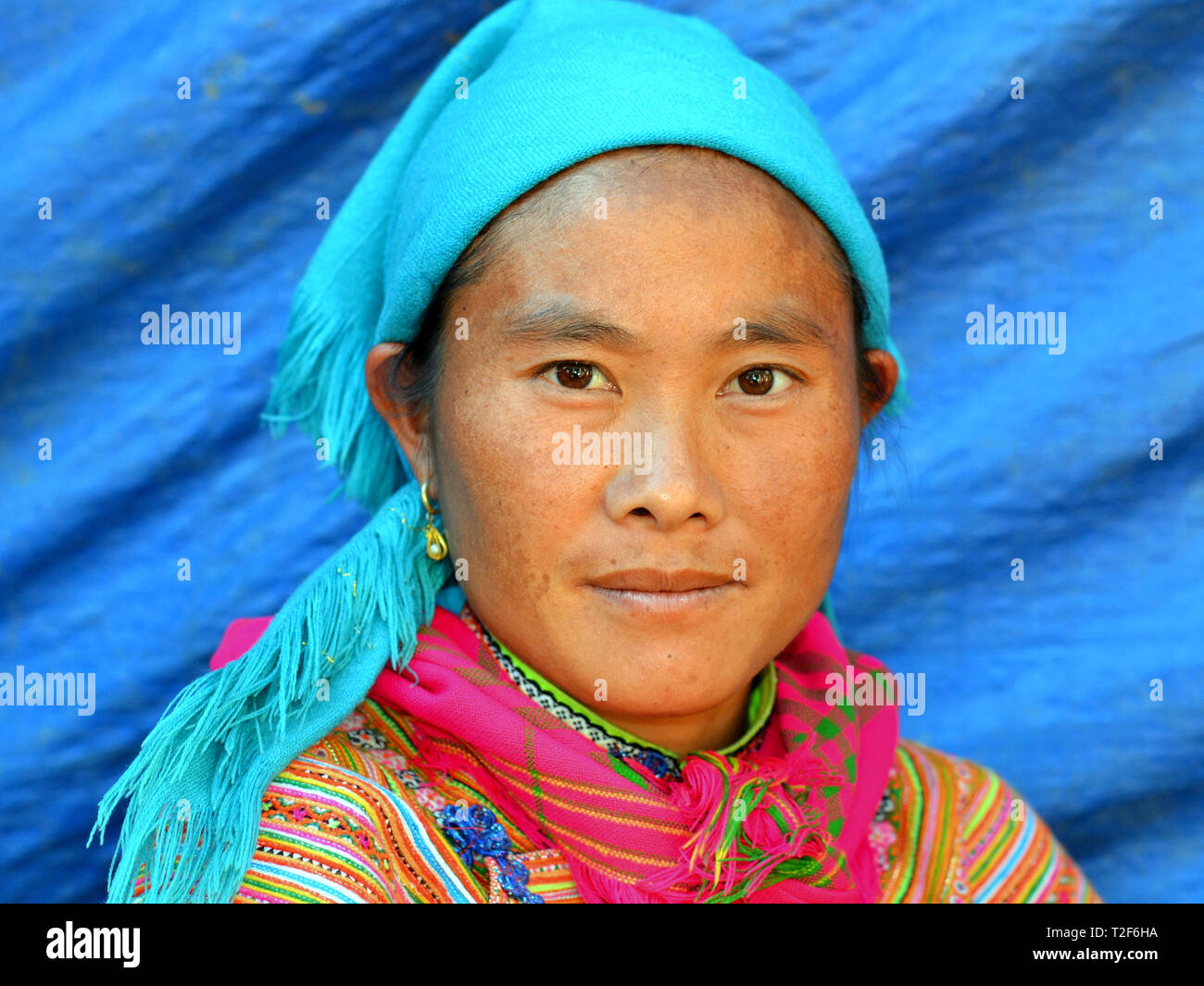 Junge vietnamesische Blume H'mong Frau trägt eine bunte gestickte traditionelle Blume H'mong Kostüm und posiert für die Kamera. Stockfoto