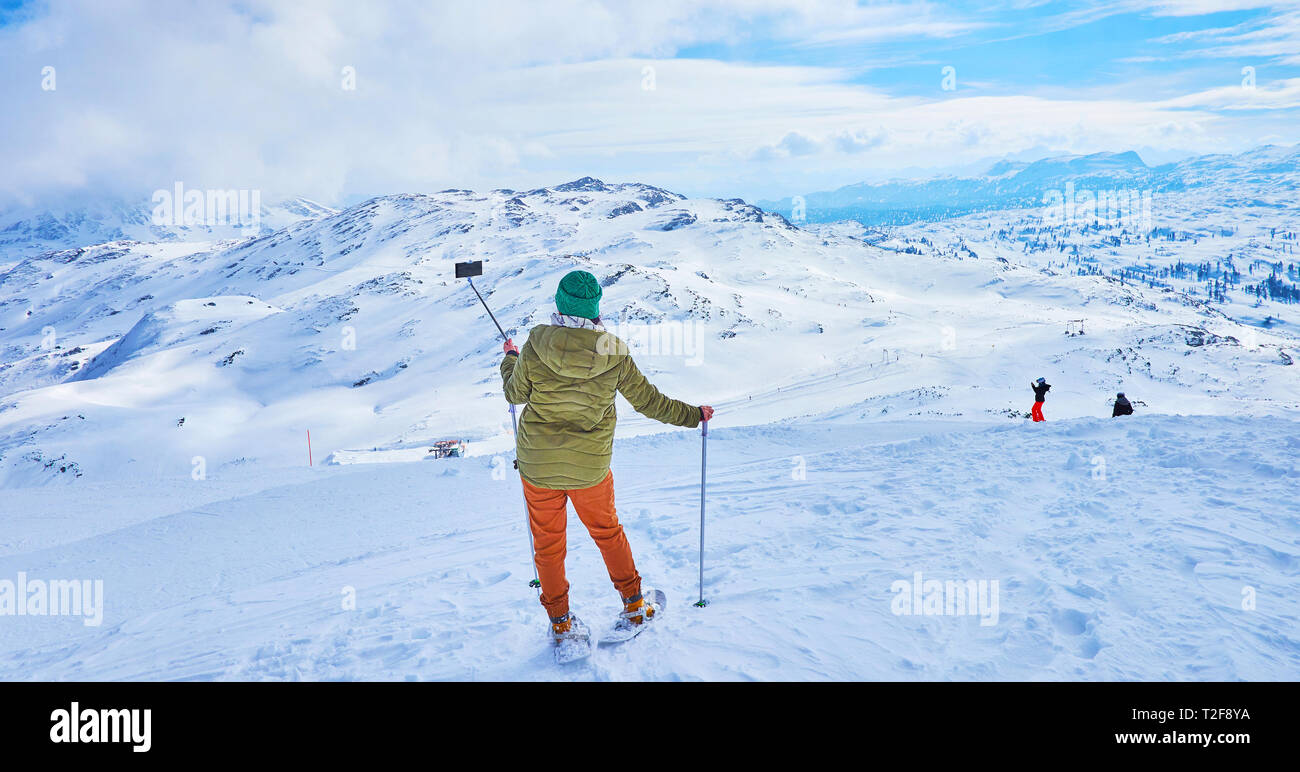 Die jungen snowshoer genießt die wunderbare Bergwelt des Dachsteins Alpen und nimmt eine selfie, posiert auf dem verschneiten Hang des Krippenstein Stockfoto