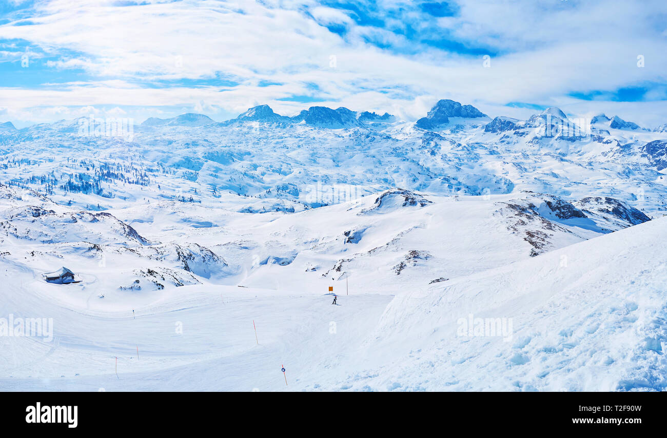 Die Steigung der Krippenstein Berg mit Blick auf das Dachsteinmassiv der Nördlichen Kalkalpen mit ihren Gletschern, scharfe Kegel, foggy Gipfeln und beste Ski pis Stockfoto