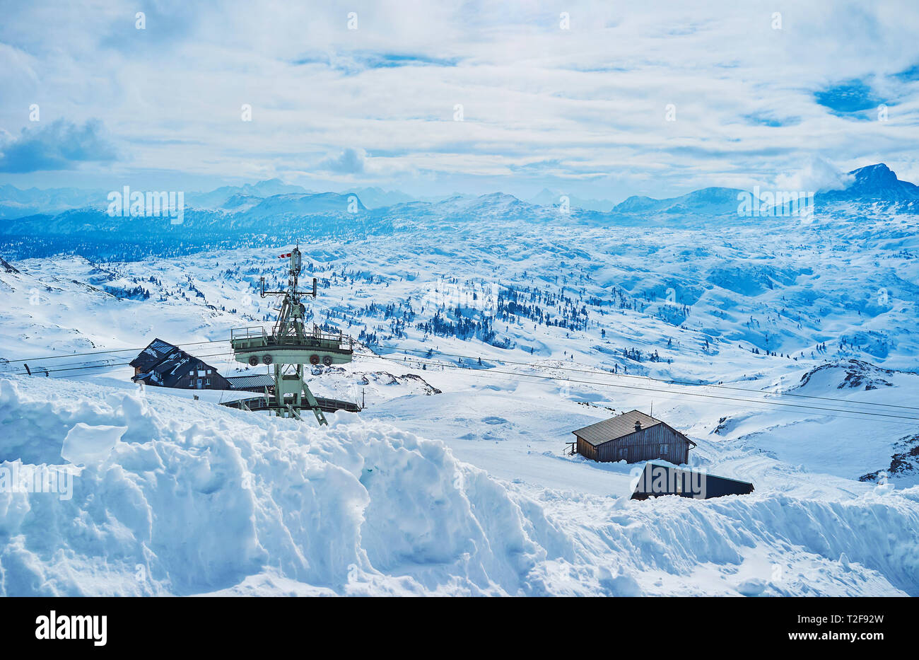 Der Blick auf die Seilbahn Turm und malerischen Entlastung der Dachstein Alpen aus der Steigung der Krippenstein mount mit hohen Schneeverwehungen im Vordergrund, Sal Stockfoto