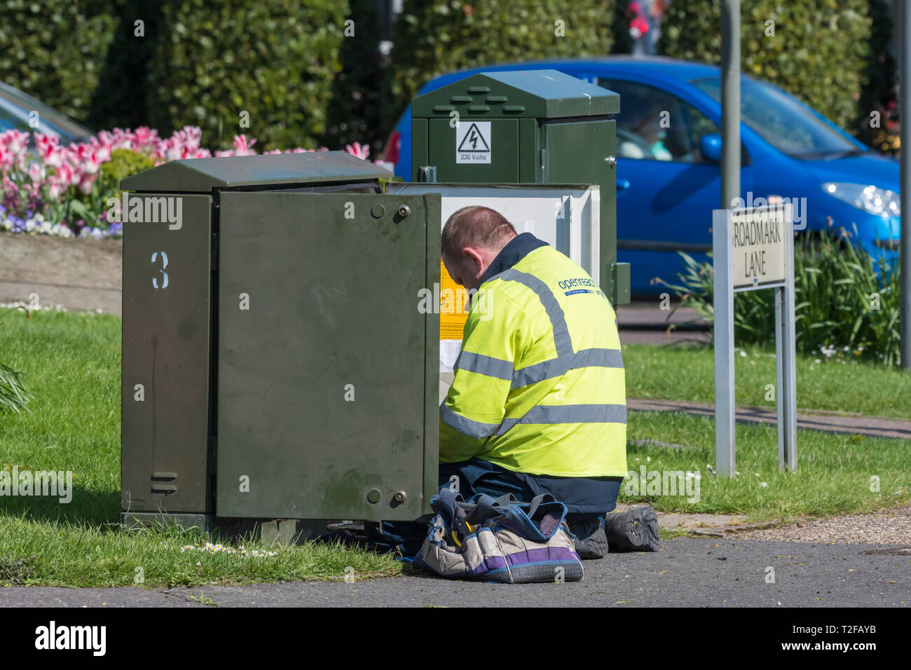 Openreach Mitarbeiter kniete in einem BT Telefon Kabinett, in Großbritannien. Stockfoto