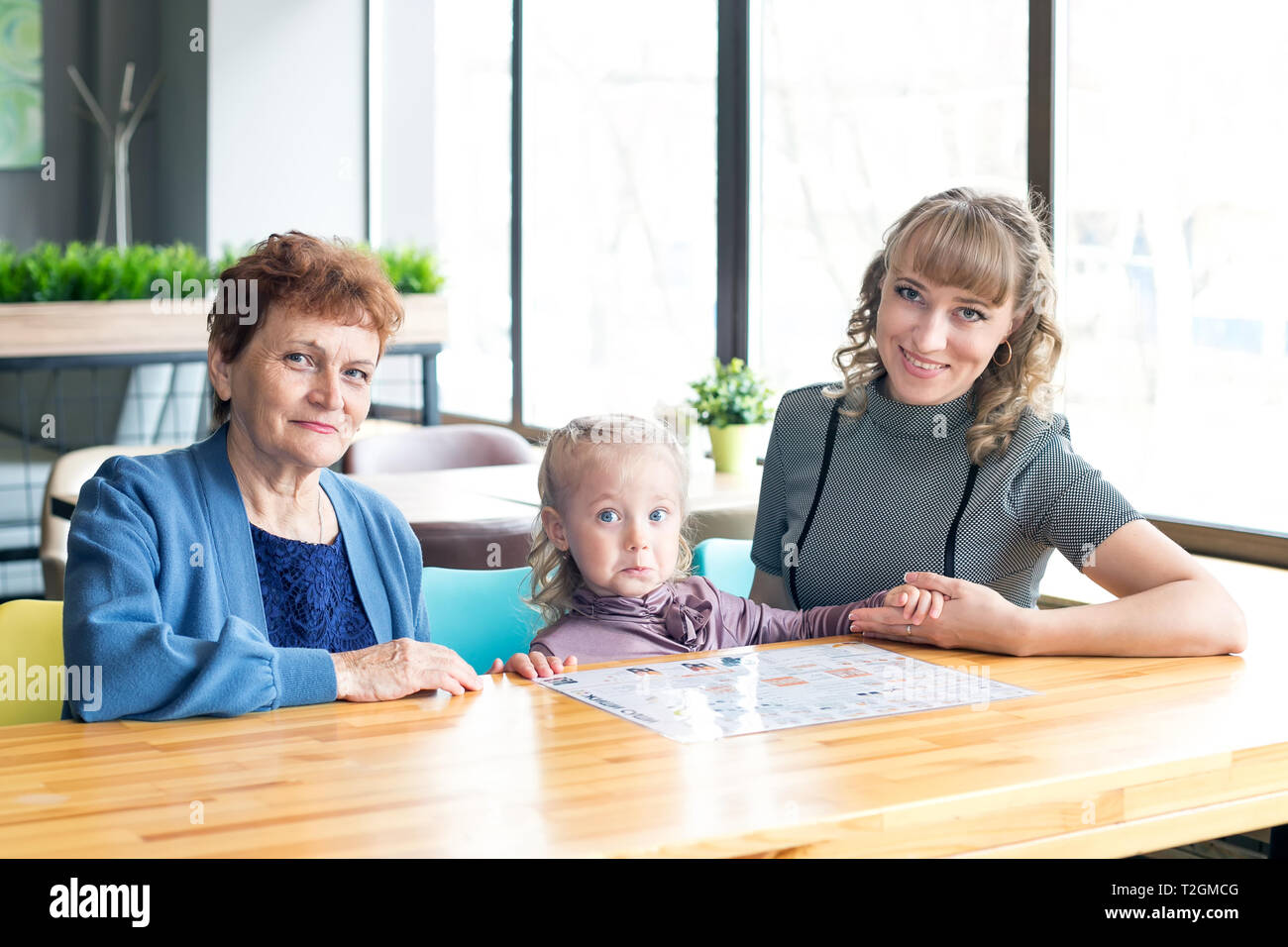 Weibliche Familie mit drei Generationen von Frauen Enkelin Mutter Großmutter beobachtete die Speisekarte in einem Restaurant. Stockfoto