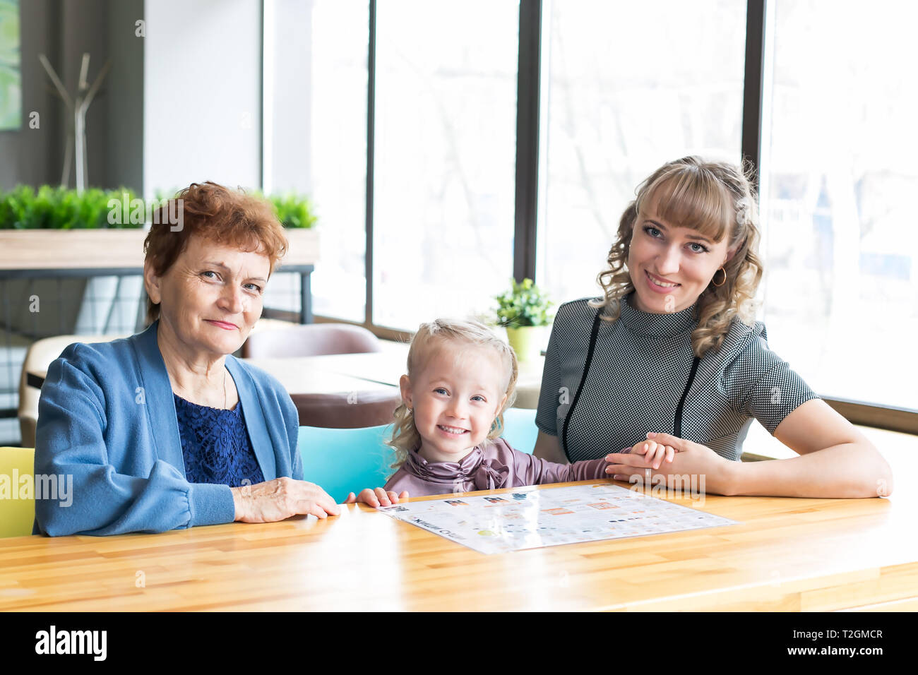 Weibliche Familie drei Generationen von Frauen Enkelin Mutter und Großmutter beobachtete die Speisekarte in einem Restaurant. Stockfoto