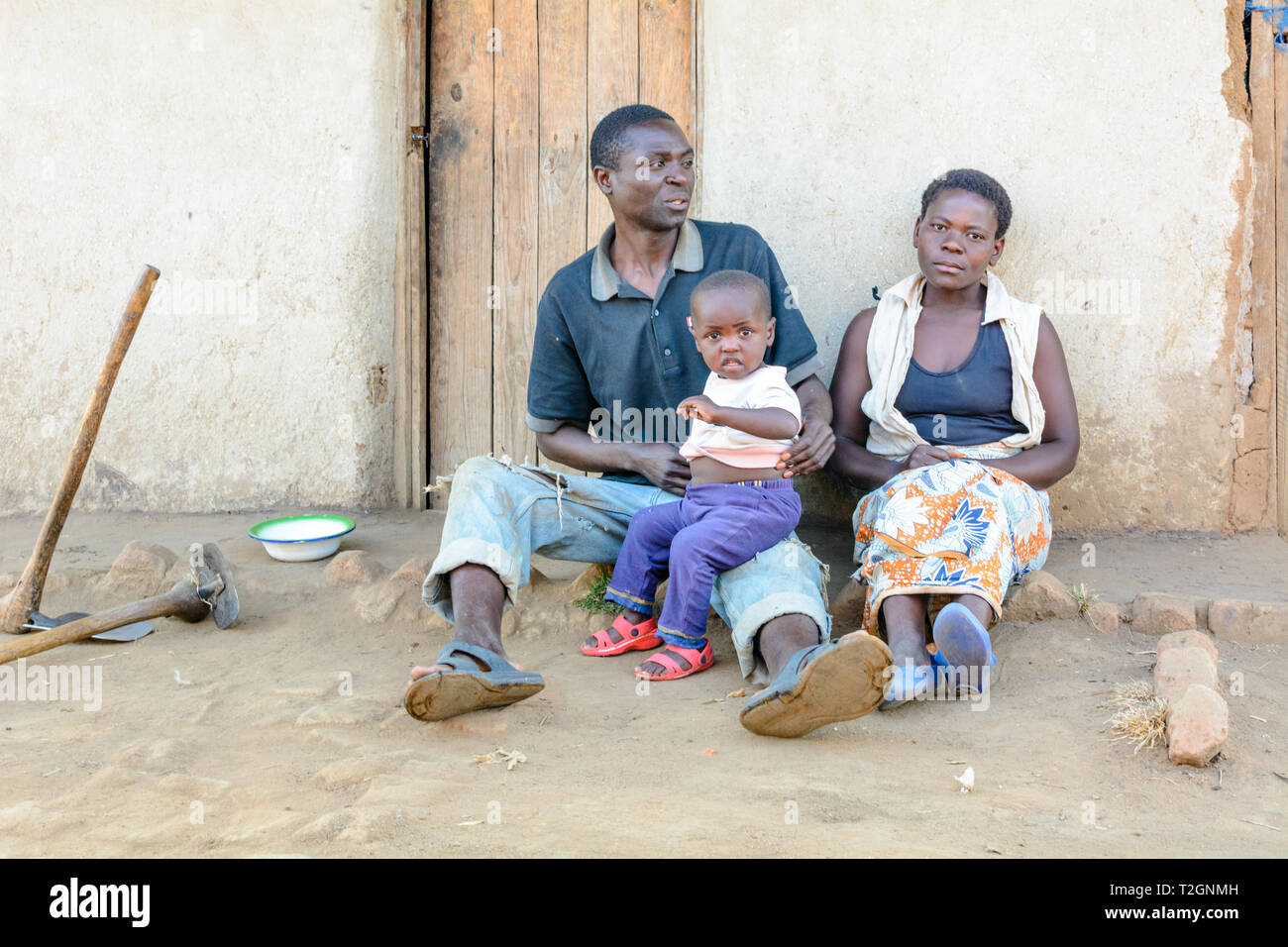Malawische Familie Rest außerhalb ihrer Hütte nach Landwirtschaft Stockfoto