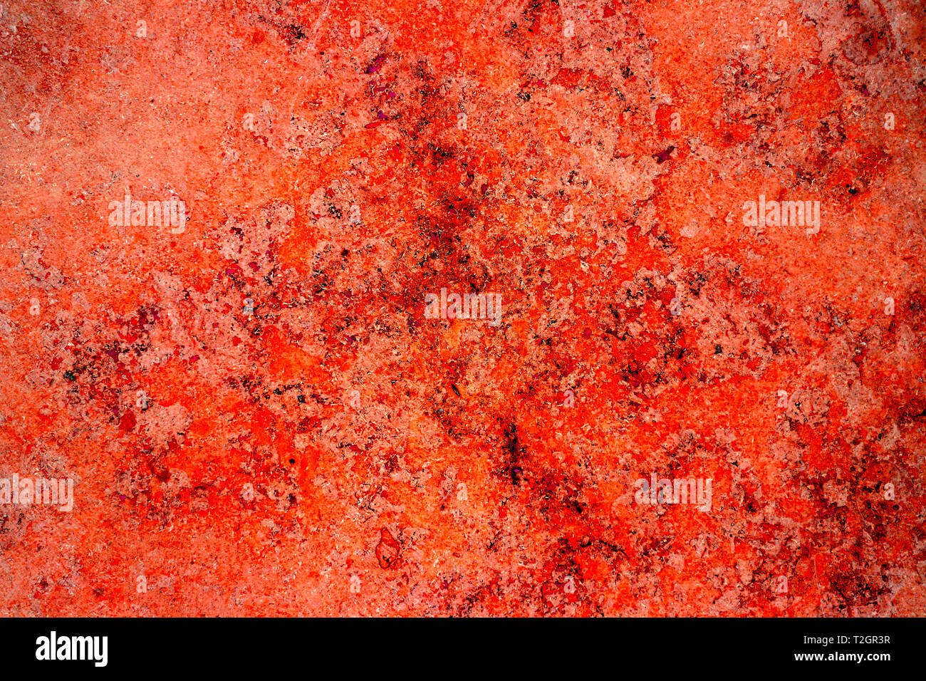 Rot rost Farbe Fassade aus Stein mit Unebenheiten, Löcher und Risse als leere rustikal und einfach abstrakte Textur Oberfläche Hintergrund. Stockfoto