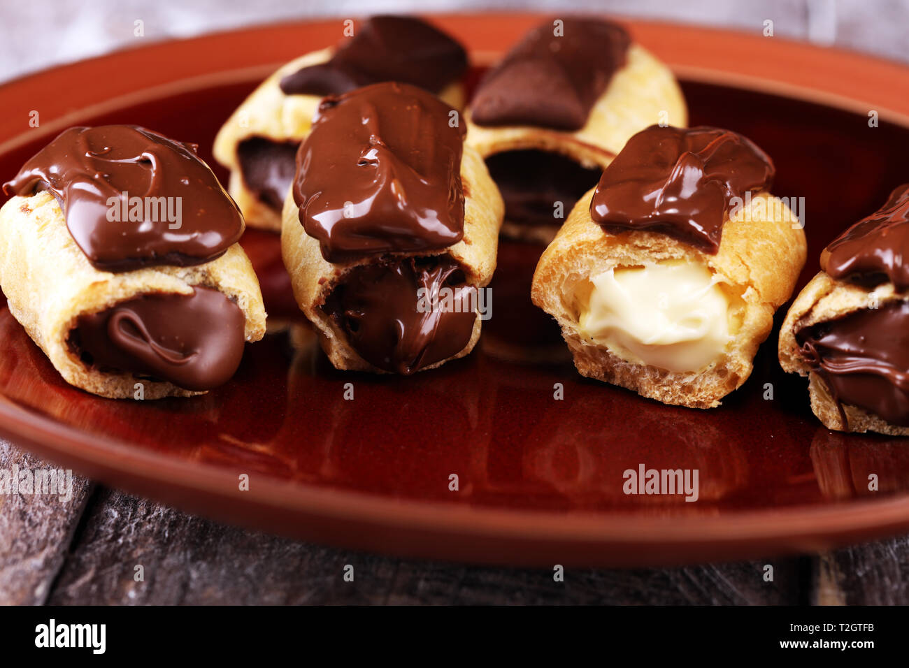 Traditionelle französische Dessert. Eclair mit Schokoladenglasur. Pastery Konzept mit weißer und dunkler Schokolade Stockfoto