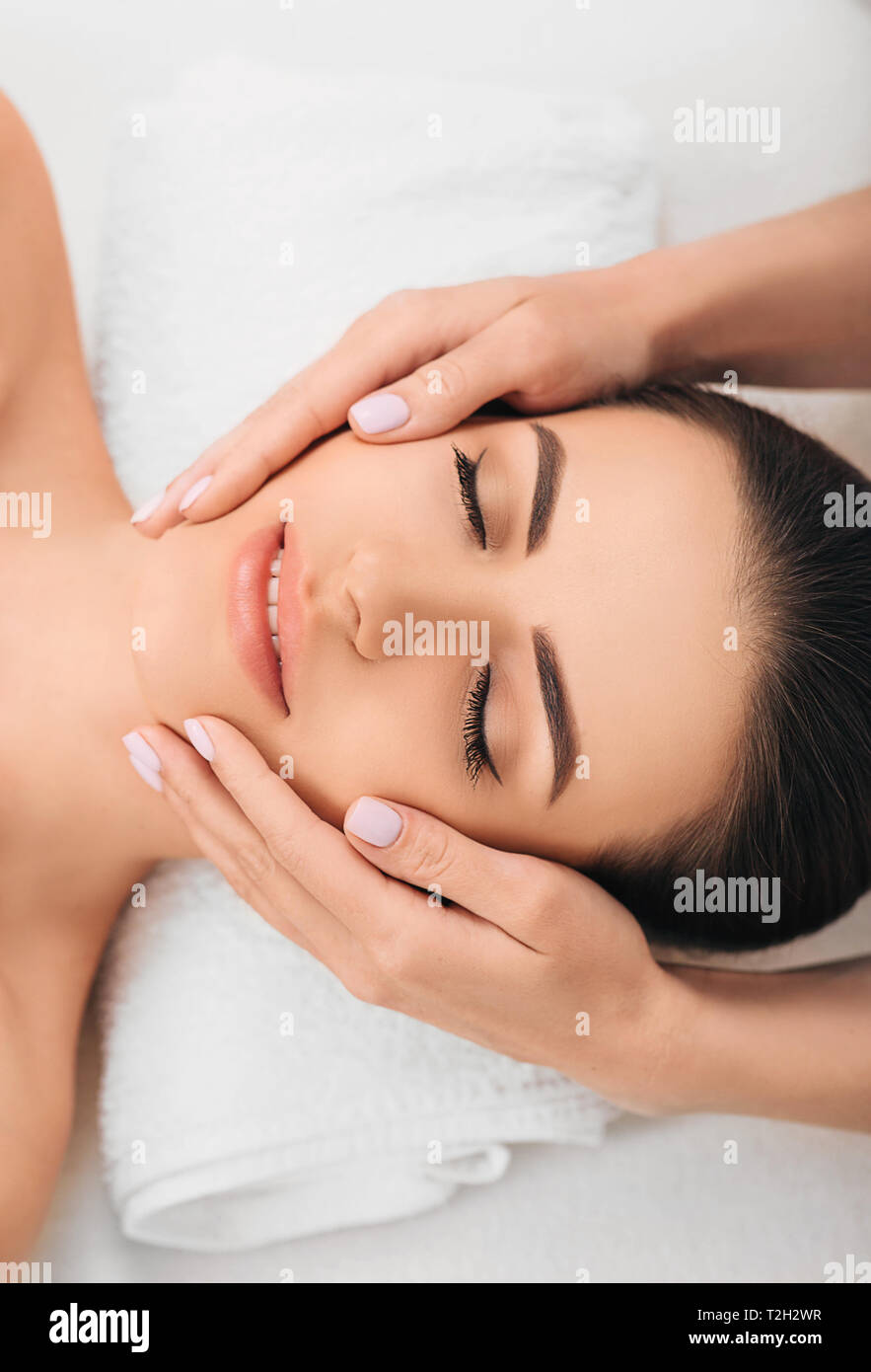 Junge Frau immer ein Kopf Massage im Spa. Gesichtsmassage mit perfekt sauber und frische Haut Stockfoto