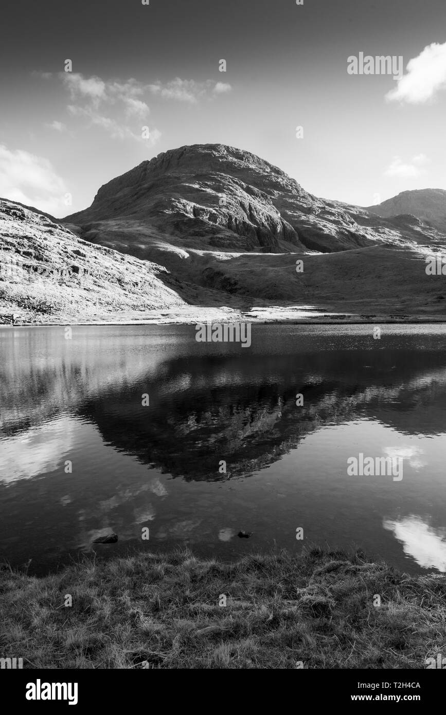 Schwarz-Weiß-Bild eines fiel in der Lake District ist in Styhead Tarn in der Nähe Scafell Pike wider. Stockfoto