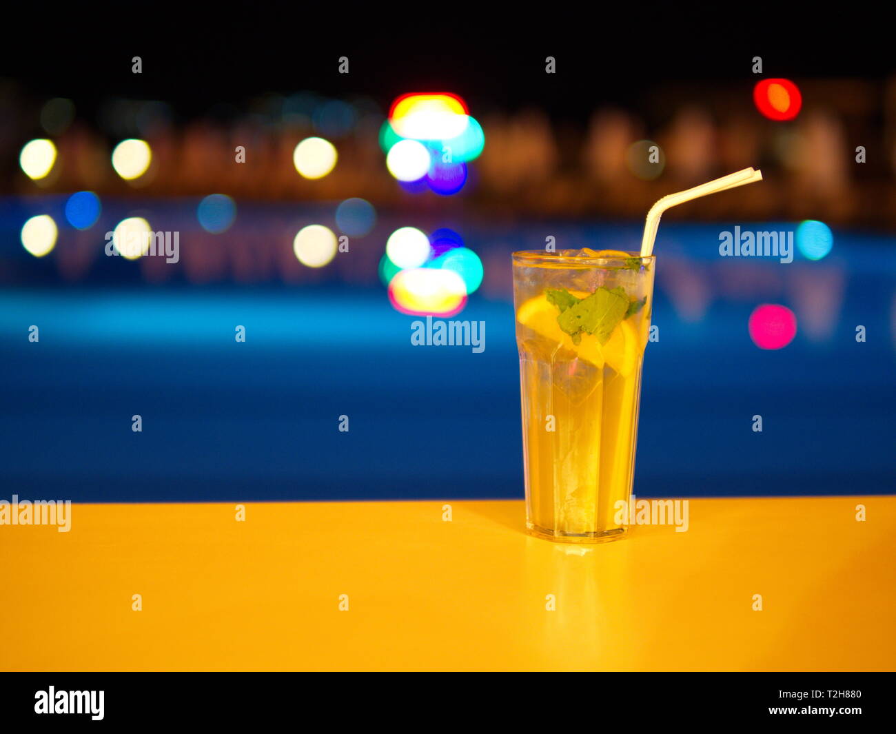 Genießen Sie einen Cocktail am Pool bei Nacht Stockfoto