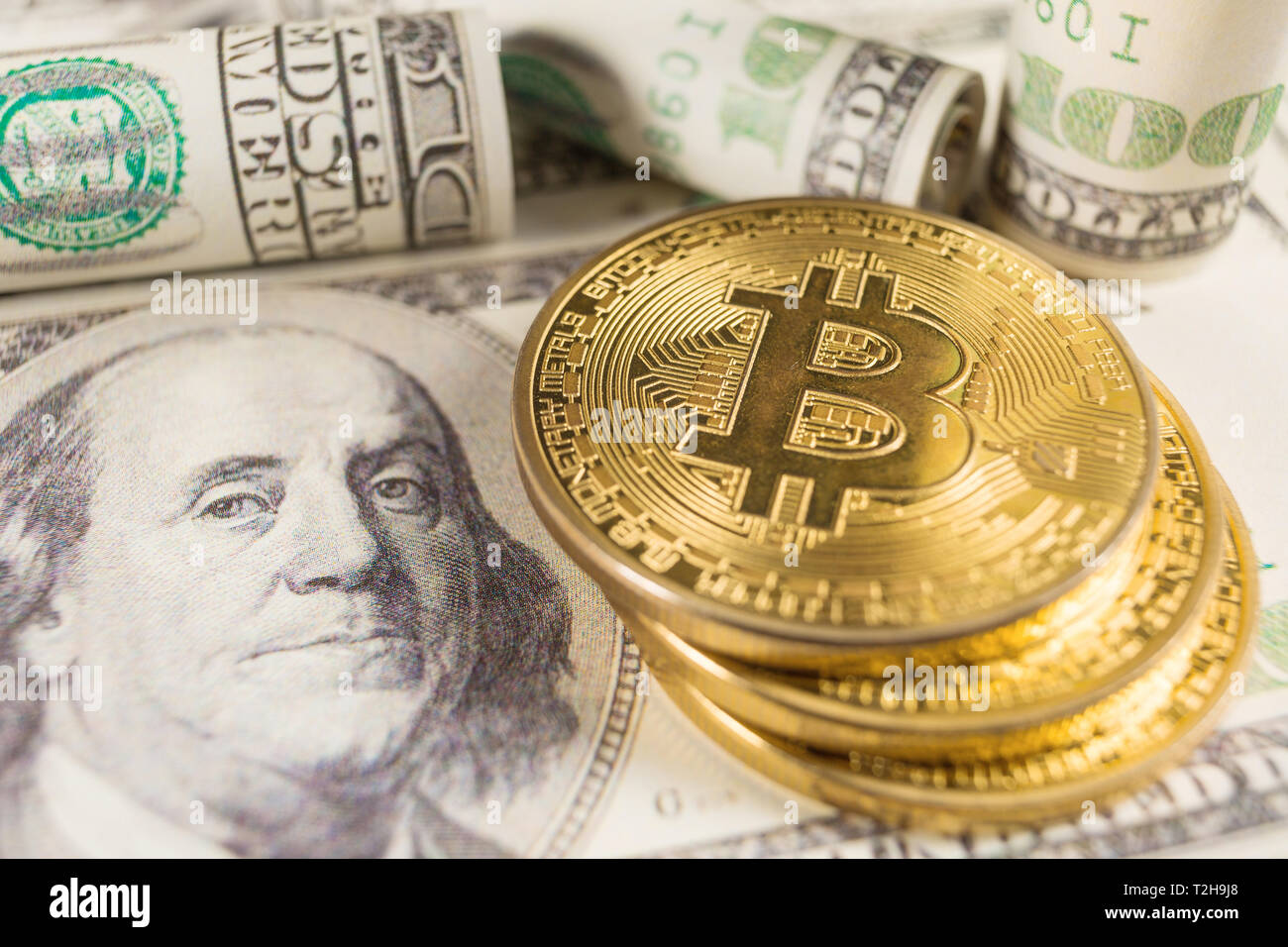 Bitcoin stack und Banknoten von hundert Dollar. Konzeptionelle Bild für globale cryptocurrency blockchain Zahlungssystem. Stockfoto