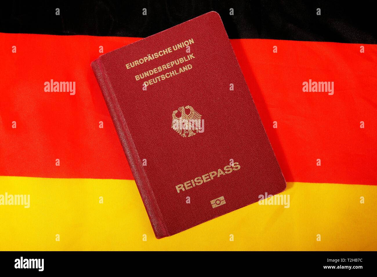 Biometrischer Reisepass der Bundesrepublik Deutschland, der Europäischen Union, Schwarz-Rot-Goldenen deutschen Nationalflagge hinter, Deutschland Stockfoto