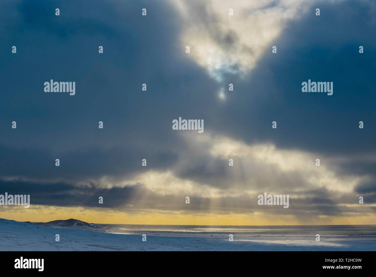 Sonnenlicht strahlt durch dunkle Wolken am Meer scheint, im Winter, Halbinsel Snaefellsnes, Island Stockfoto
