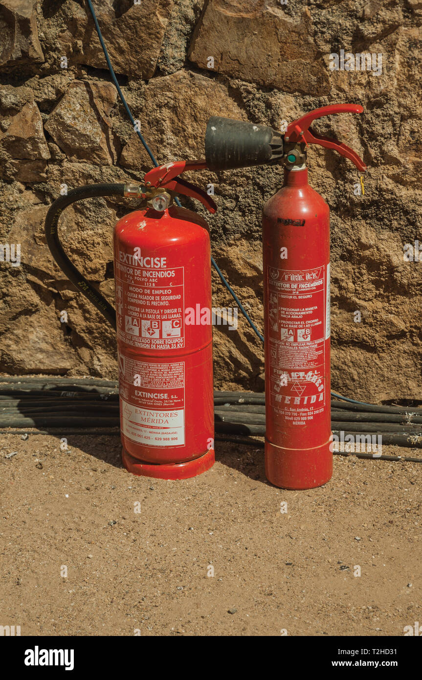 Feuerlöscher vor der Mauer aus Stein im Römischen Theater von Mérida. Die Stadt bewahrt viele Gebäude des antiken Roms in Spanien. Stockfoto