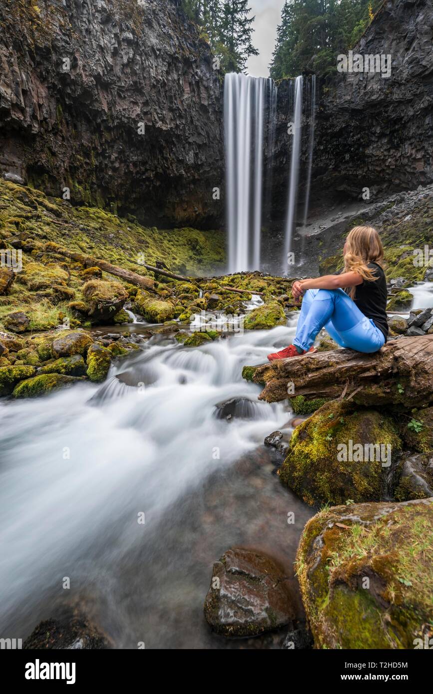 Junge Frau an einem Fluss, Wanderer sitzen, Wasserfall nach unten stürzt von einer Klippe, Zeit, Fluss Cold Spring Creek, Tamanawas fällt, Oregon, USA Stockfoto
