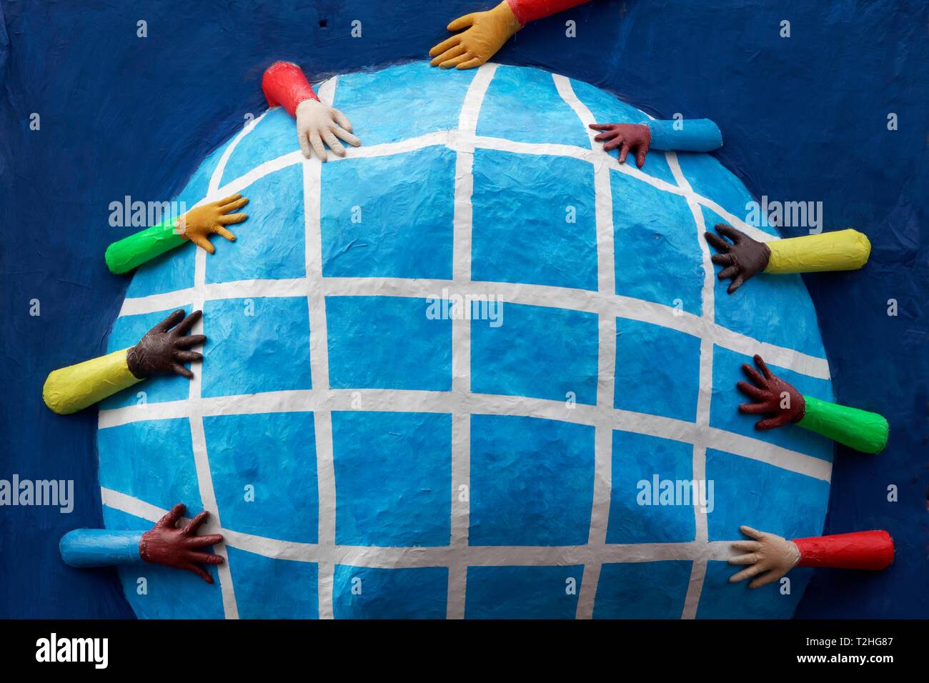 Hände mit unterschiedlichen Hautfarben erreichen für eine Kugel aus Pappmaché, Thema Auto, Symbol gegen Rassismus und für Toleranz, Rosenmontag Stockfoto