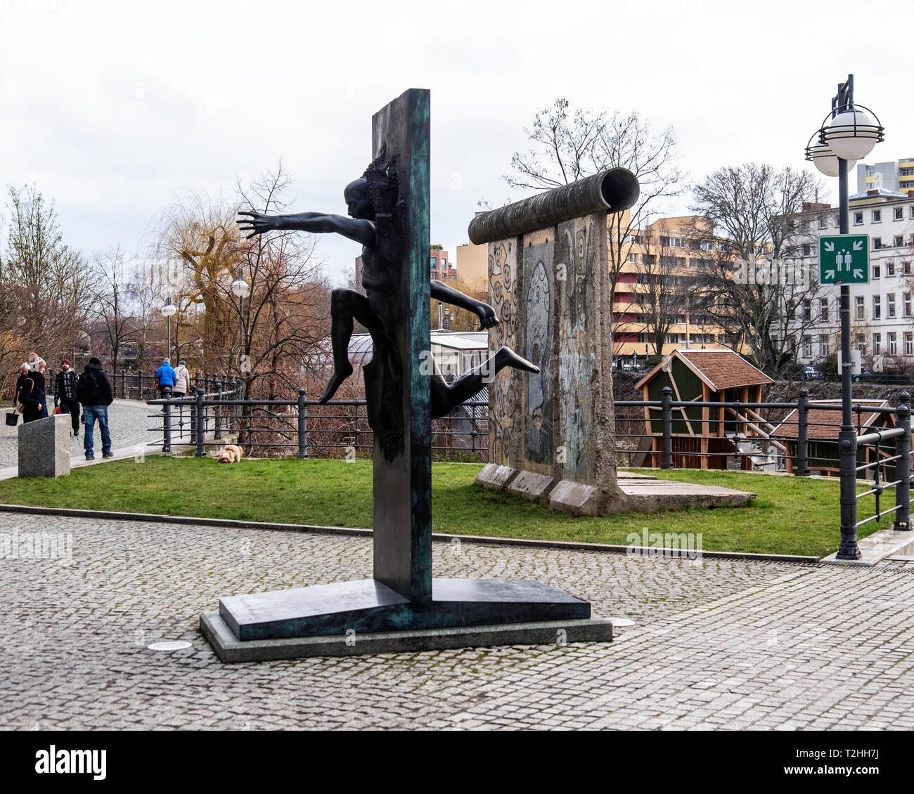 Berlin, Mitte, Moabit. Bronze Skulptur von Menschen durch die Wand von Rolf Bibi-Symbol des Mauerfalls in Berlin auf der Straße der Erinnerung. Stockfoto