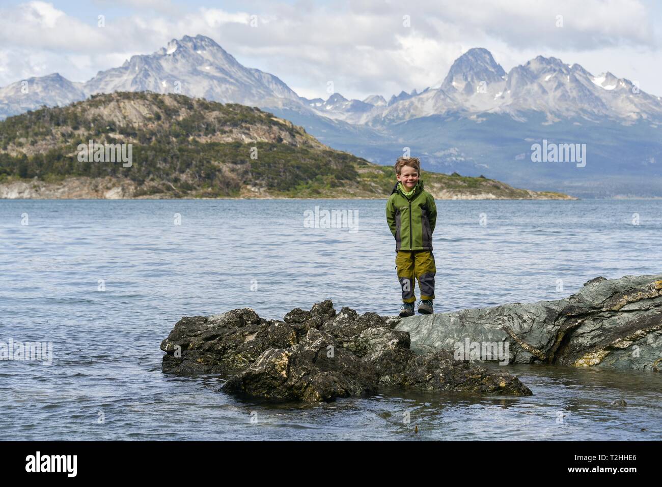 Little Boy steht auf Felsen an den Ufern des Beagle Kanal, Fin del Mundo, Ende der Welt, Parque Nacional Tierra del Fuego National Park Stockfoto