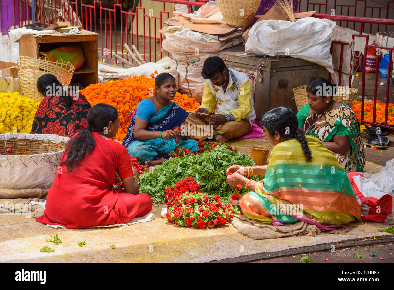 Frauen im Flower arbeiten Abschaltdruck am K.R. Markt in Banaglore, Karnataka, Indien, Asien Stockfoto
