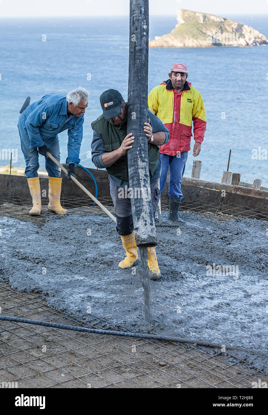 Agathopes: April 2nd, Männer Arbeiten auf der Baustelle mit frischem Zement mit Betonpumpe. Syros April 2nd, 2019, Griechenland. Stockfoto