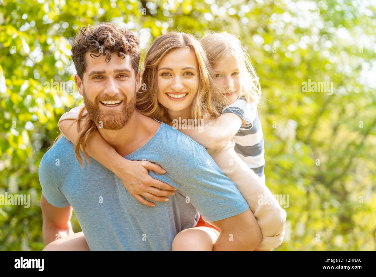 Starker und zuverlässiger Mann seine Familie unterstützt durch die Frau und Sohn piggyback Stockfoto