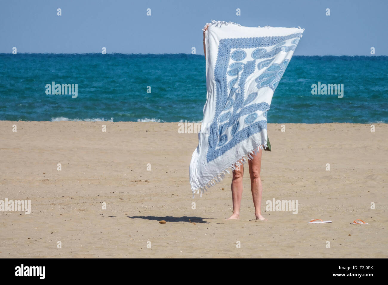 Valencia Strand Malvarrosa, einsame Frau Handtuch Strand Meer und Himmel Spanien Meerblick Frau am Strand Frau allein malerische Minimalismus versteckte Frau Stockfoto