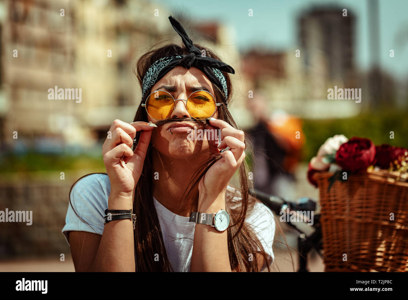 Recht glücklich junge Frau genießen und Spaß haben, schnurrbärte mit Haaren, in einem Sommer sonnigen Tag, neben dem Fahrrad mit Blumenkorb. Stockfoto