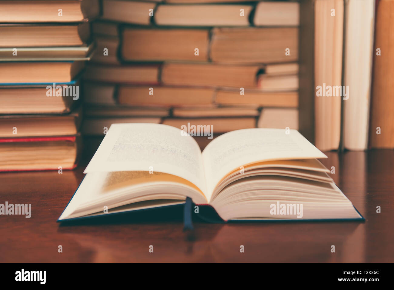 Offenes Buch Auf Dem Tisch Auf Dem Hintergrund Vieler Bucher Stockfotografie Alamy