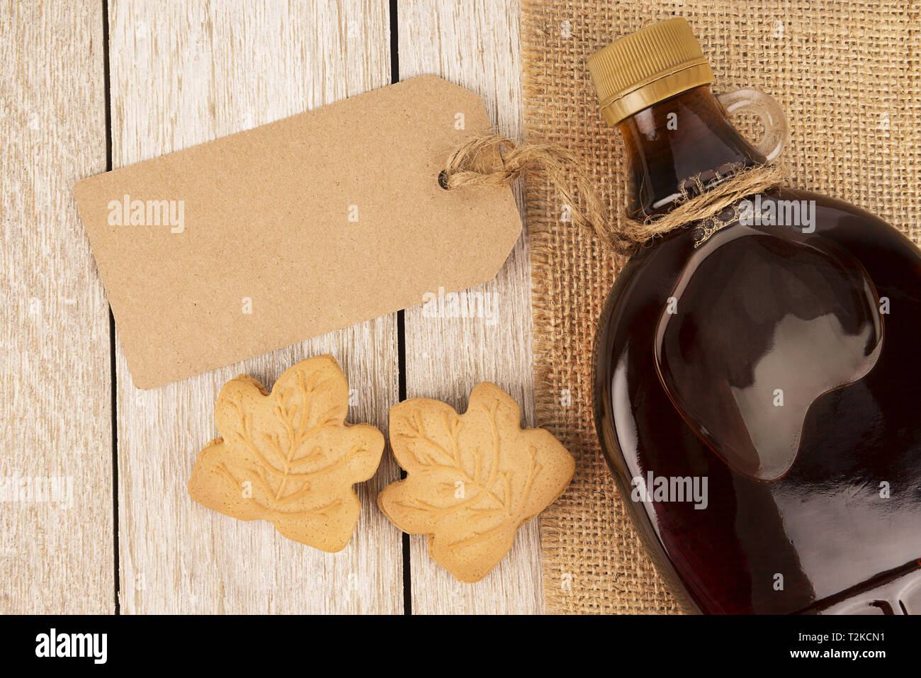 Ahorn Sirup Flasche auf einem Holzbrett. Ahornblätter in der Dekoration. Kopieren Sie Platz für Ihren Text. Stockfoto