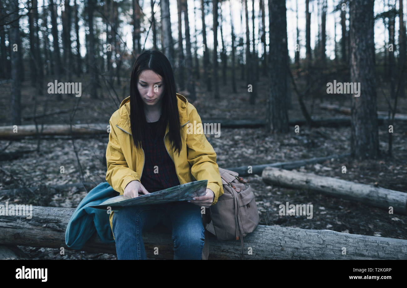Frau wandern im Wald sieht auf der Karte Stockfoto