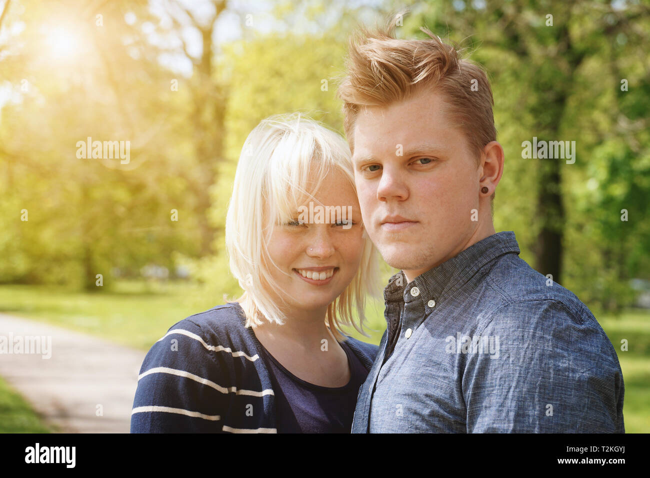 Junges Paar mit sonniger Frühlingstag in einem Park - reale Menschen mit Sonne flare leichte Undichtigkeit Filter Stockfoto