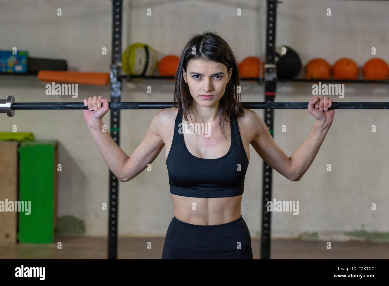 Das Mädchen ist mit einem barbell in der Turnhalle eingerückt Stockfoto