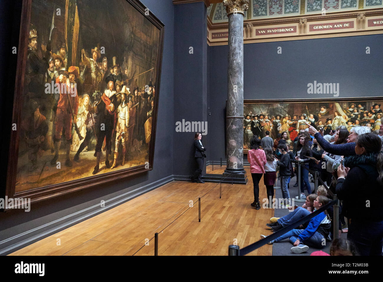 Die Besucher des Rijksmuseum beobachten das Gemälde "Nachtwache" von Rembrandt. 2019 markiert den 350. Jahrestag der Rembrandts Tod. Stockfoto