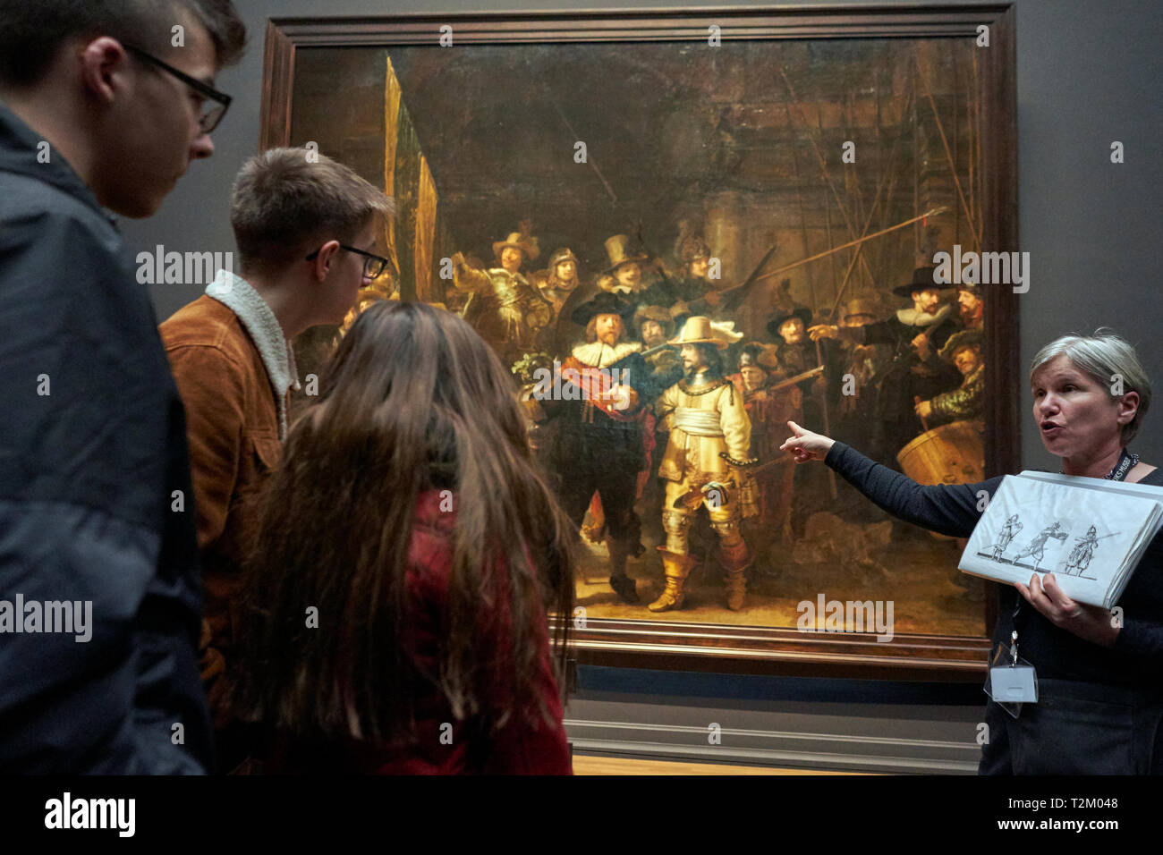 Die Besucher des Rijksmuseum beobachten das Gemälde "Nachtwache" von Rembrandt. 2019 markiert den 350. Jahrestag der Rembrandts Tod. Stockfoto