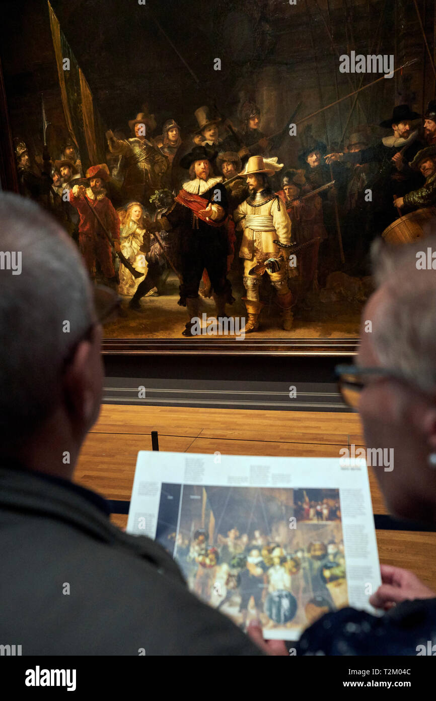 Die Besucher des Rijksmuseum beobachten das Gemälde "Nachtwache" von Rembrandt. 2019 markiert den 350. Jahrestag der Rembrandts Tod. Stockfoto