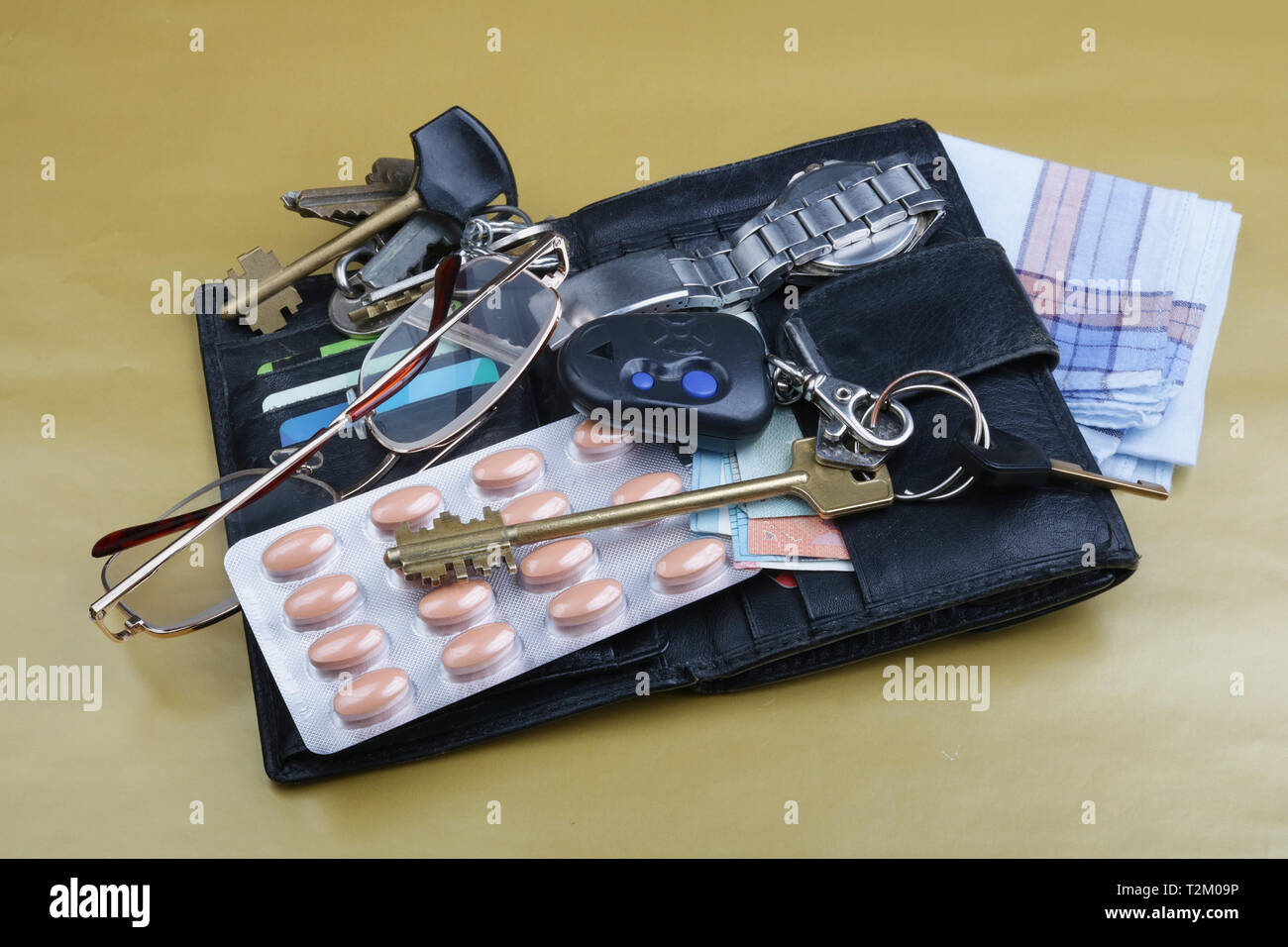 Der Inhalt der Taschen von einem älteren Mann sind die Schlüssel, Brillen und Pillen. Stockfoto