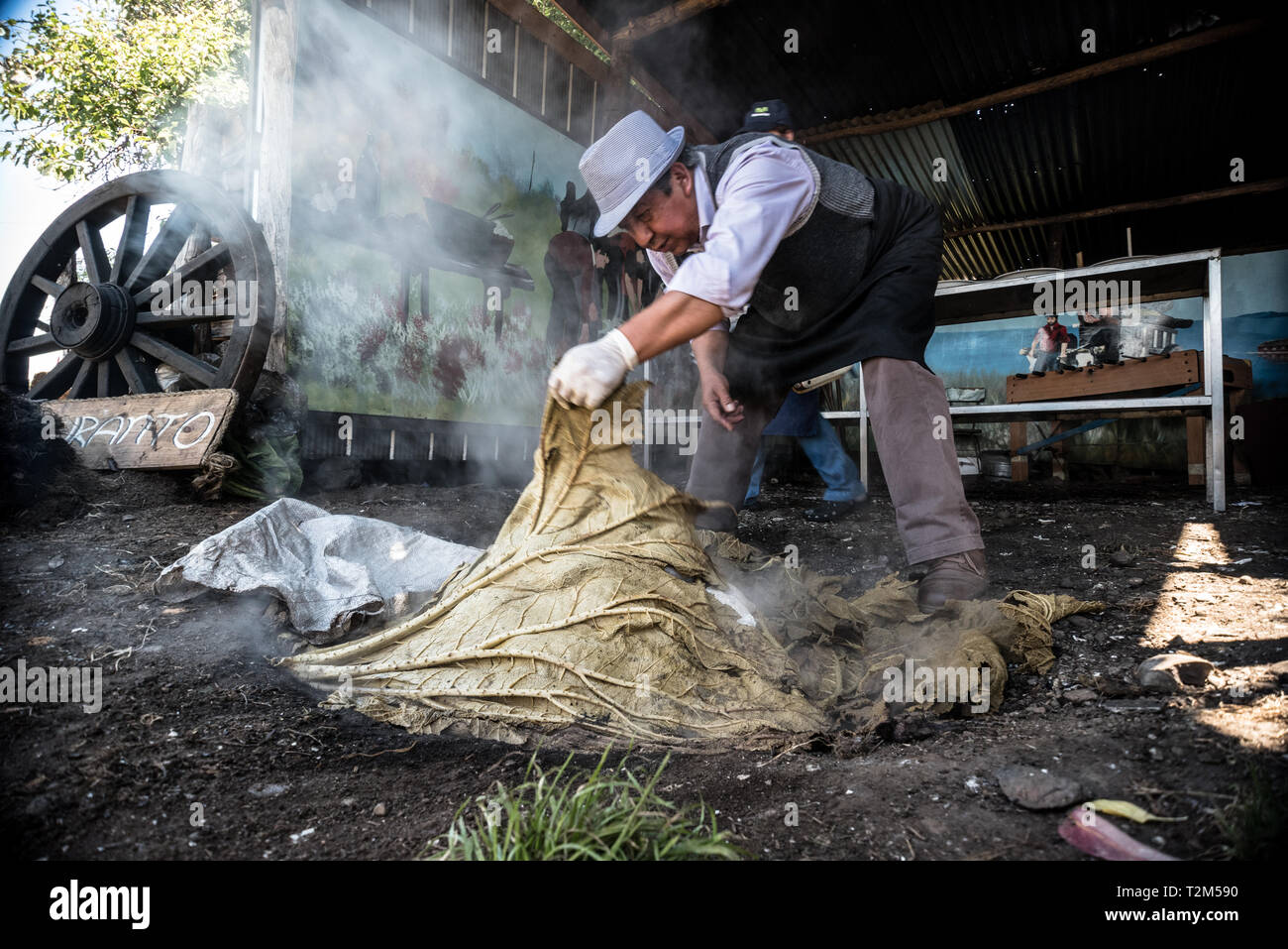 Chiloé/Chile - am 14. Januar 2017: der Mann, der das Kochen ein typisches Gericht namens curanto in einem Ganzen im Boden in den Süden von Chile Stockfoto