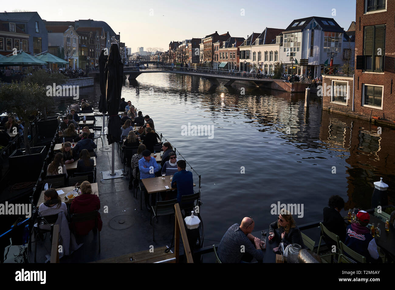 Eine Gruppe von Leuten, die etwas Trinken auf einer der Terrassen in einer der wichtigsten Kanäle, die die Stadt Leiden Kreuz entfernt sitzen. Stockfoto